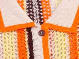 Gros plan sur le haut polo en maille crochet multicolore avec des boutons en résine brune