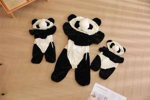 Combinaisons panda en peluche douce en trois tailles sur un sol en bois chaud