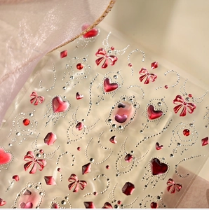 Detailopname van decoratieve nagelstickers met roze hartjes en strikjes voor Valentijn