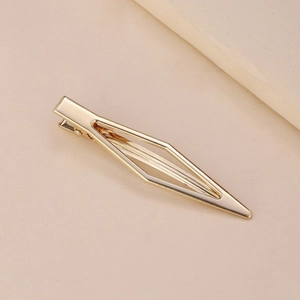 Minimalist gold metal hair clip featuring a hollow geometric rhombus design on beige background
