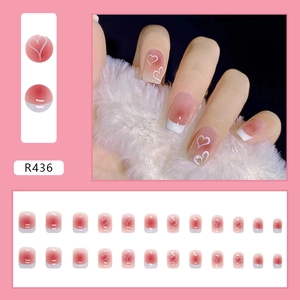 Eleganti unghie finte corte rosa con cuori bianchi e stile French Tips modello R436