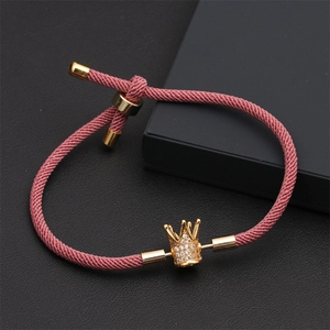 Détail d'un bracelet couronne tissé rose avec accents dorés et oxydes de zirconium