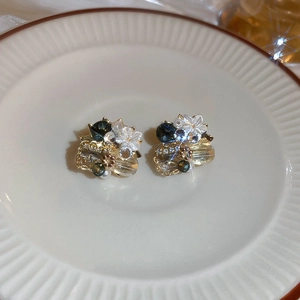 Detail of vintage flower earrings with green beads and sparkling starburst crystals