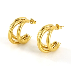Close-up of golden triple-row C-shaped hoop earrings with a matte brushed metal finish
