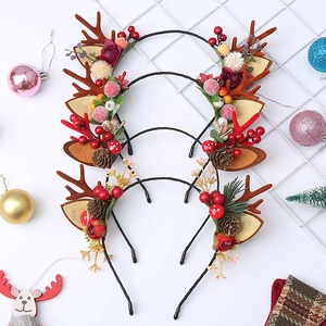 Detailed set of four reindeer antler headbands with pine cones and red berries for Christmas