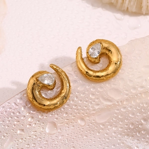 Macro shot of 18K gold snake coil earring featuring a drop-shaped cubic zirconia stud