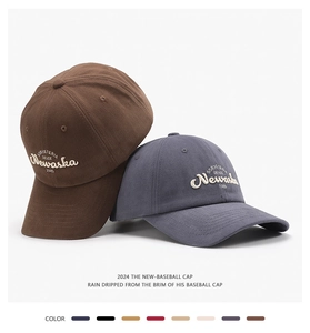 Close-up of premium cotton baseball caps showing 3D letter embroidery and stitched brim