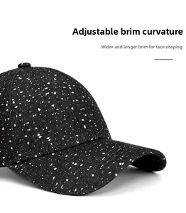 Détail de la casquette avec bord large pliable et texture unique à éclaboussures de peinture