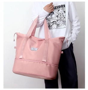 Detail of pink waterproof travel bag showing large capacity structure and carry handles