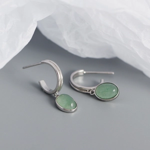 Detail of S925 silver C-shape earrings with green oval aventurine stone pendants