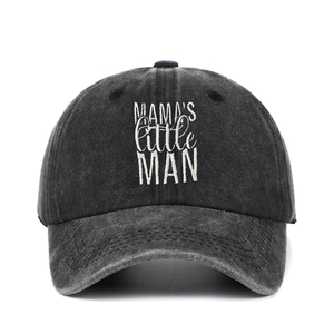 Close-up of white MAMA'S little MAN embroidery on washed black cotton baseball cap