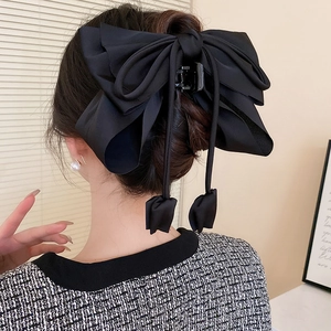 Grande pince à cheveux élégante en satin noir stylisée sur un chignon de style français
