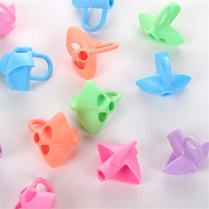 Close-up of colorful silicone dolphin pencil grips for posture correction on white background