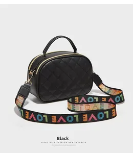 Detail der schwarzen Stepptasche mit bunt besticktem LOVE-Webschultergurt