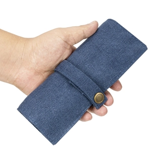 Detail der blauen Uhrenarmband-Rolltasche aus Segeltuch mit Messing-Druckknopfverschluss