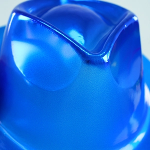 Macro detail of the bright metallic blue top hat featuring high-gloss reflective texture