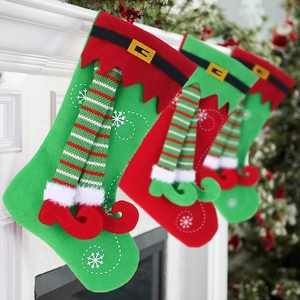 Christmas stockings with elf legs and snowflake embroidery hanging on a festive mantelpiece