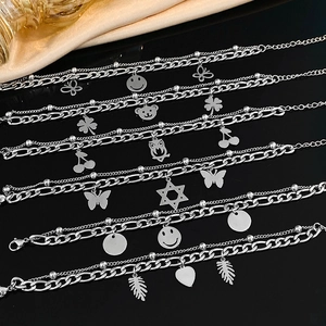 Double-layer stainless steel bracelet with butterfly and smiley face charms on black surface
