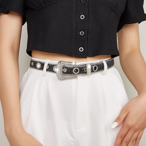 Detail of Y2K rhinestone studded black leather belt with sparkling metal buckle on model