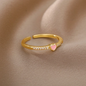 Macro detail of 18K gold adjustable ring featuring a pink enamel heart and zircon stones