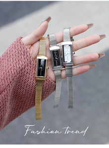Close-up of minimalist rectangular quartz watch with sleek metal stretch band on wrist