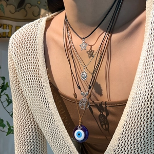 Détail du collier ethnique à 4 couches avec oeil bleu, arbre de vie et pendentifs soleil