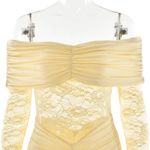 Detailed close-up of lace stitching and ruched satin texture on a light yellow dress