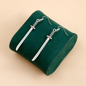 Vue détaillée de la boucle d'oreille épée en argent sur un support en velours vert