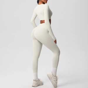 Detail view of cream long sleeve yoga top and high waisted leggings showing slim fit curves
