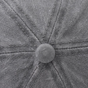 Macro shot of dark gray cotton twill baseball cap crown with stitched panels and top button