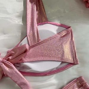 Detail of pink glitter bikini top featuring removable pads and lace-up side design