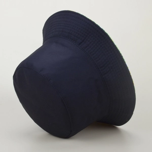 Detail view of the navy bucket hat showing its thick twill fabric and patterned brim lining