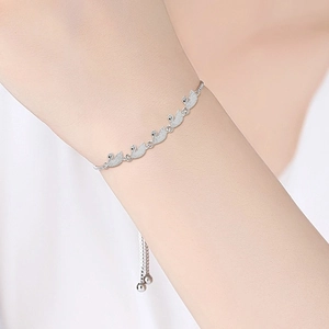 Detail eines verstellbaren Silberarmbands mit Schwanenmotiven am Handgelenk eines Modells