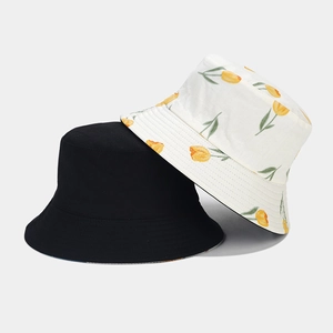 Détail d'un chapeau bob réversible en coton avec imprimé tulipes et tissu noir uni