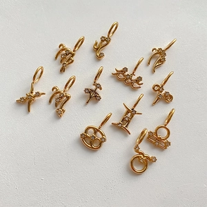 Colgantes DIY de los signos del zodiaco bañados en oro con pedrería fina sobre fondo blanco