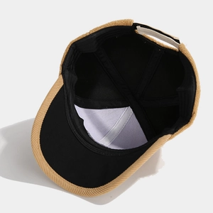 Detail view of khaki corduroy baseball cap showing black inner lining and reinforced stitching