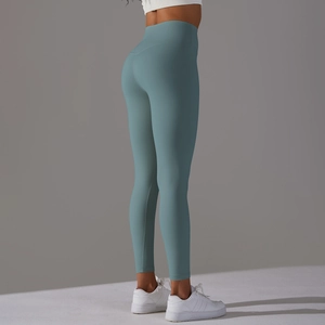 Side view of high-waisted seamless yoga leggings in light teal green on a model