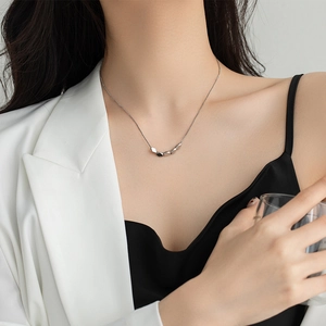 Minimalist silver geometric necklace with five faceted cube pendants on a model