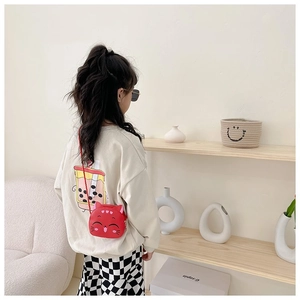 Toddler modeling a red cat-shaped silicone crossbody bag with cute whiskers and ears