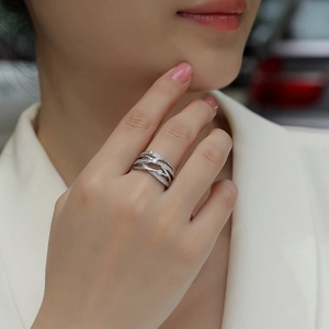 Elegant multi-layered crisscross silver ring with sparkling stones worn by a model