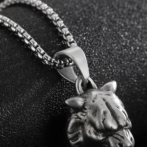 Detailed macro view of vintage lion head whistle pendant on round box chain