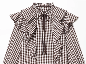 Détail de chemise vintage à carreaux marron avec volants et encolure à cordon de serrage