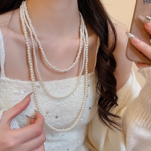 Dettaglio della collana di perle multistrato vintage con lucentezza bianco crema