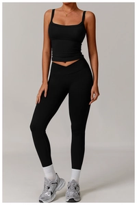 Détail du legging de yoga noir à taille croisée en V et haut court de sport assorti