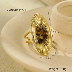 Detailed view of an oval gold stainless steel ring with brown stone and shell texture