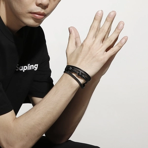 Close-up of black multilayer braided leather bracelet with magnetic steel clasp on wrist