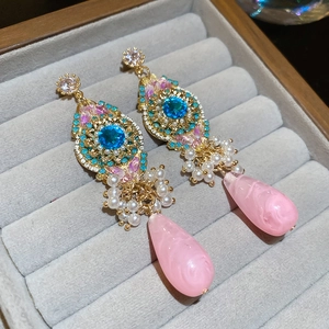 Detail of luxury vintage drop earrings with blue stone, pearls and pink teardrop pendant