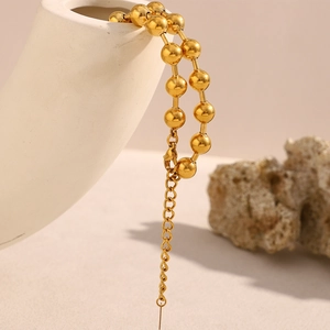 Dettaglio della collana a sfere dorate con chiusura a moschettone e catenella regolabile
