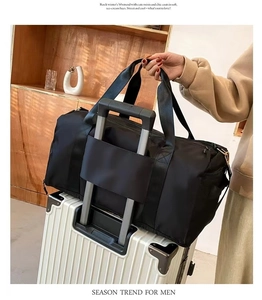 Black nylon travel bag with trolley sleeve attached to a white suitcase handle
