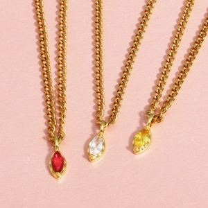 Detailed view of marquise-cut gems in red, white and yellow on gold chains